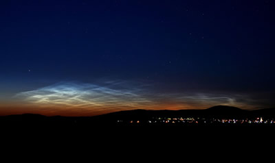 <a href="/earth/Atmosphere/NLC.html&edu=high">Noctilucent</a>
  clouds are the highest clouds in the sky, but they are not associated with
  weather like the <a
  href="/earth/Atmosphere/clouds/cloud_types.html&edu=high">other
  clouds</a> we regularly see in the sky. Noctilucent clouds form very high in
  the <a href="/earth/Atmosphere/overview.html&edu=high">atmosphere</a>,
  in the <a
  href="/earth/Atmosphere/mesosphere.html&edu=high">mesosphere</a>.
  They are best seen from Earth at sunset. This image was taken on June 15,
  2007, in Budapest, Hungary. Normally seen from locations near the <a
  href="/earth/polar/polar.html&edu=high">poles</a> of
  the Earth, in recent years they have also been seen at much lower-latitude
  locations.<p><small><em> Image Courtesy of NASA/Veres Viktor</em></small></p>