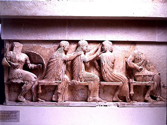 Left 
section of the east frieze of the Siphnian Treasury (c. 525 B.C.) depicting 
from left to right <a 
href="/mythology/Definitions_gods/Venus_def.html&edu=high">
Venus</a>, <a 
href="/mythology/Diana_def.html&edu=high">
Diana</a>, and <a 
href="/mythology/Definitions_gods/Apollo_def.html&edu=high">
Apollo</a>. This portion of the frieze shows the gods sitting, watching the 
Greeks raid Troy.<p><small><em>   Image courtesy of the Superintendency (Ephoria) of Prehistoric and Classical Antiquities in Delphi. Greek Ministry of Culture-Archaeological Receipt Fund. (c) Greek Ministry of Culture.</em></small></p>