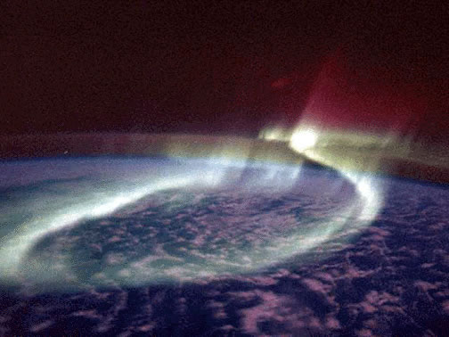 A sinuous glowing band of <a
  href="/earth/Magnetosphere/aurora.html">aurora</a> (the Aurora Australis
  or Southern Lights) loops around the <a
  href="/earth/polar/polar_south.html">southern polar</a>
region in the
  distance as viewed by astronauts onboard the space shuttle on <a
  href="http://www.nasa.gov/mission_pages/shuttle/shuttlemissions/archives/sts-39.html">STS-039</a>. 
  <a
  href="/earth/Magnetosphere/aurora/aurora_colors.html">Aurora are produced</a>
  when <a
  href="/physical_science/physics/atom_particle/particle_radiation.html">energetic particles</a>
 entering the Earth's
  atmosphere from space interact with <a
  href="/physical_science/physics/atom_particle/atom.html">atoms</a> and <a
  href="/earth/geology/molecule.html">molecules</a> in the atmosphere and
  release energy, emitted as light.<p><small><em>Courtesy of NASA, Astronaut Overmeyer and Dr. Hallinan</em></small></p>